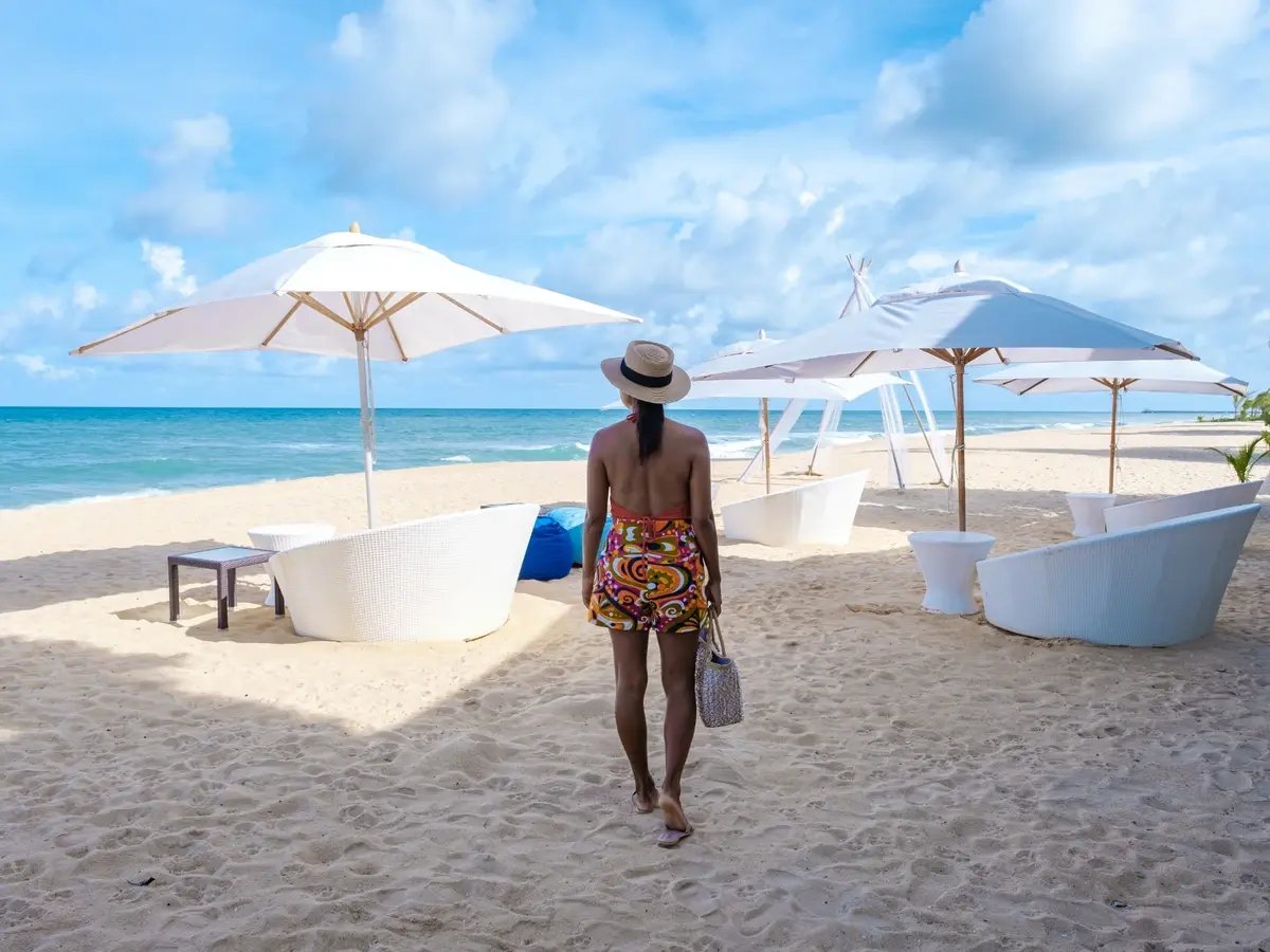 asian-elegant-woman-walking-on-the-beach-with-hat